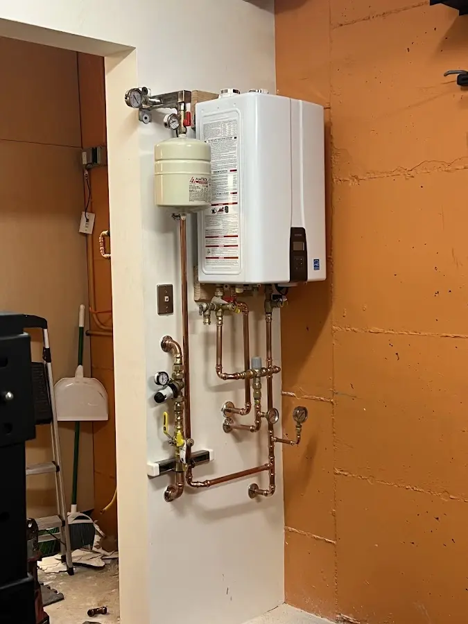 Plumbing technician inspecting water heater connections in Kannapolis